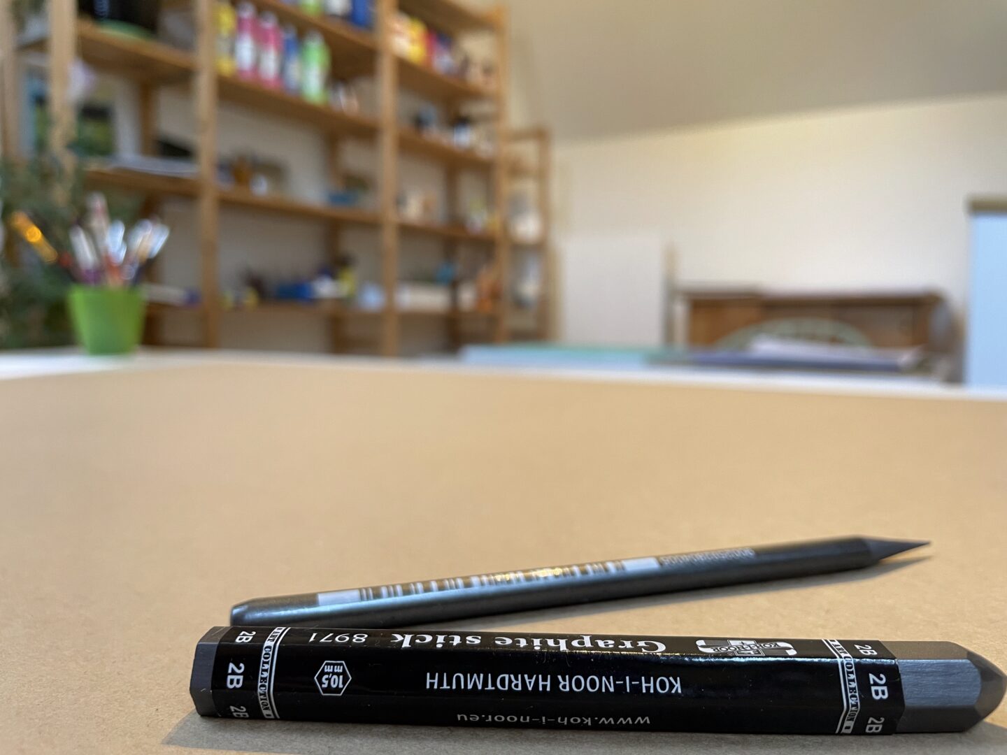 Zwei Graphitstifte auf einem brauen Karton in einem Kunsttherapie Atelier